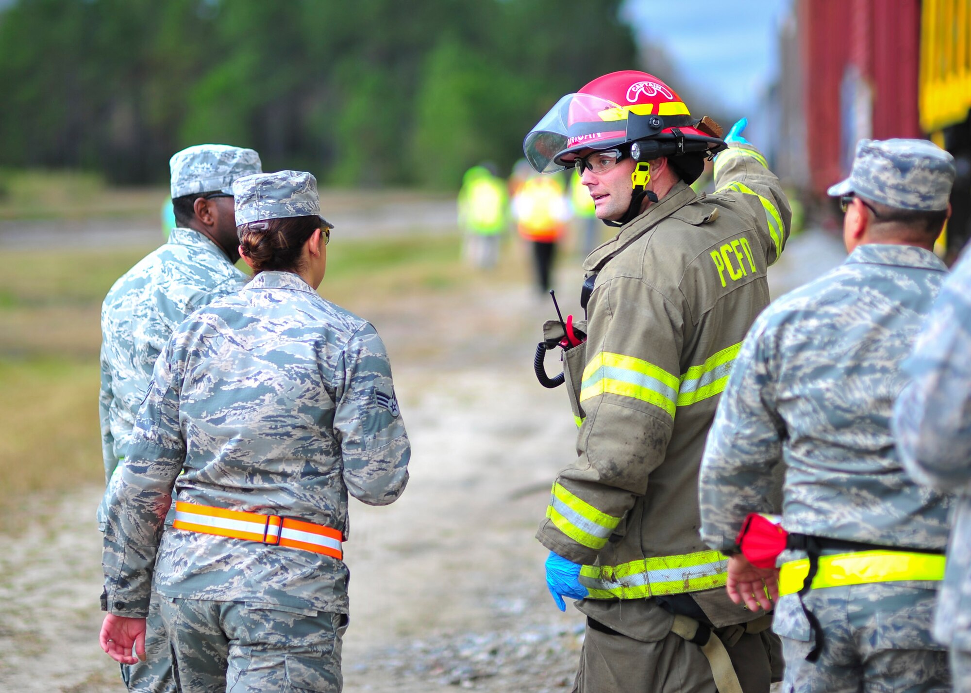 A Panama City Fire Department firefighter talks to Tyndall Airmen during a training exercise Dec. 17 at the Panama City Bay Line Railroad. More than 40 members of Tyndall joined over 150 people from local agencies to participate in an extensive train environment exercise. (U.S. Air Force photo by Senior Airman Dustin Mullen/Released)