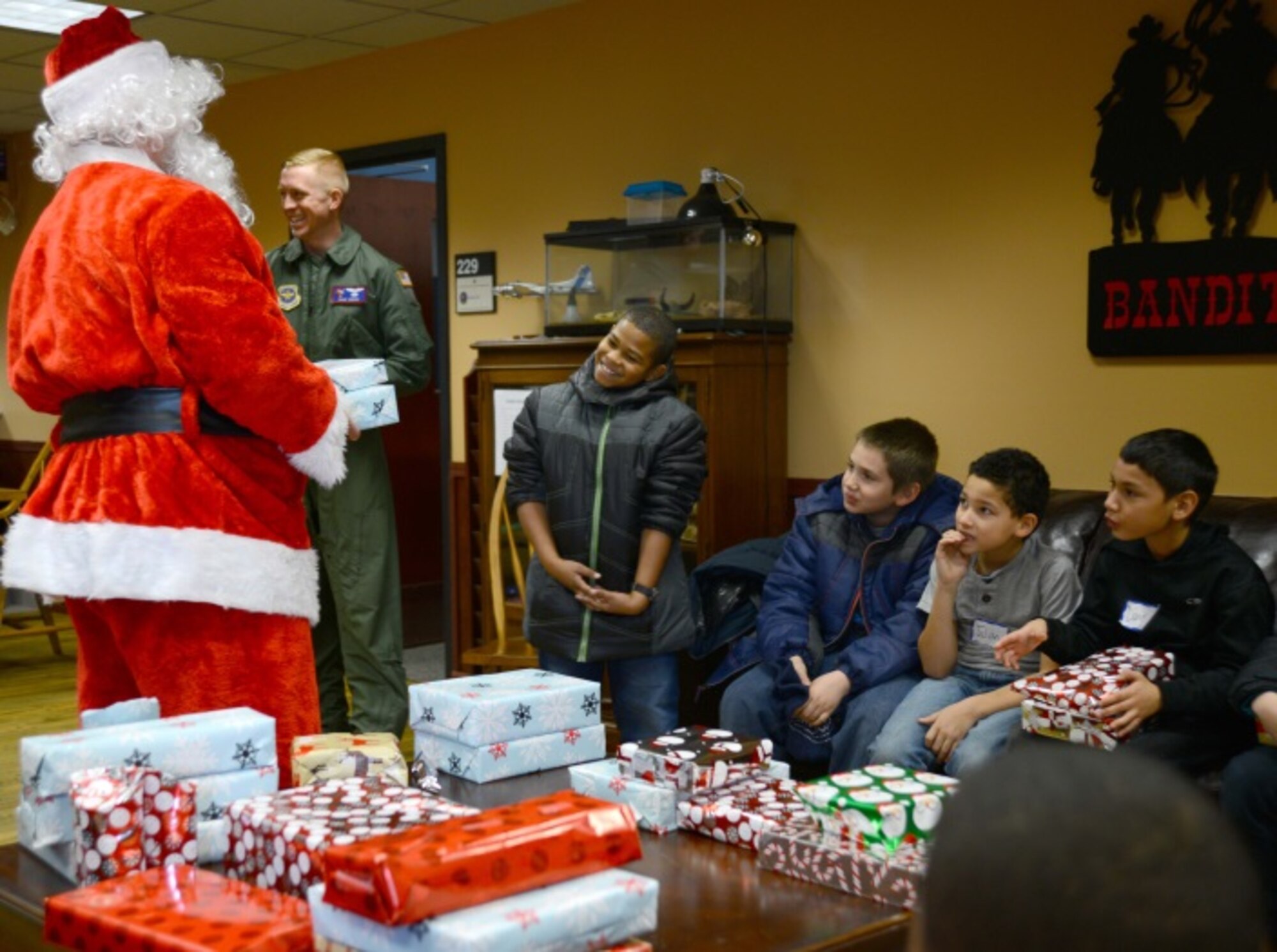 Children from the Big Brothers Big Sisters of Wichita answer Santa’s questions before receiving wrapped presents during a visit to McConnell Air Force Base, Kan., for Operation Santa Dec. 18, 2015.  Airmen of the 349th Air Refueling Squadron gave a tour of McConnell to 18 children and also handed out Christmas presents. (U.S. Air Force photo/Airman 1st Class Christopher Thornbury) 