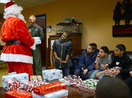 Children from the Big Brothers Big Sisters of Wichita answer Santa’s questions before receiving wrapped presents during a visit to McConnell Air Force Base, Kan., for Operation Santa Dec. 18, 2015.  Airmen of the 349th Air Refueling Squadron gave a tour of McConnell to 18 children and also handed out Christmas presents. (U.S. Air Force photo/Airman 1st Class Christopher Thornbury) 