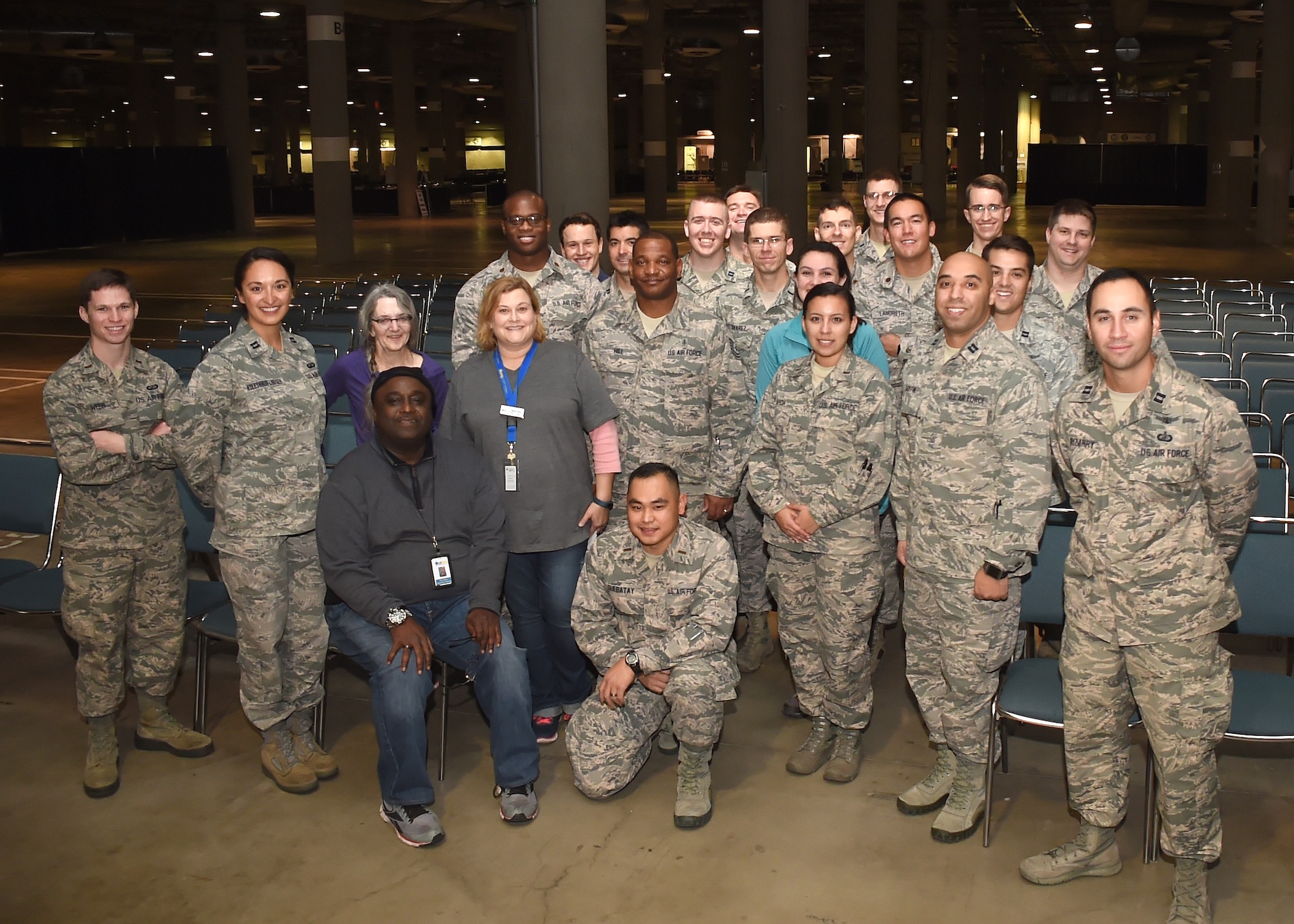 Ivan Mason, seated left, executive director of U.S. Vets Inglewood, takes a group picture with a set-up crew of volunteers comprised of active duty personnel from the Space and Missile Systems Center at Los Angeles Air Force Base in El Segundo, Calif. More than 65 volunteers from SMC participated in the 2nd annual L.A. Vets Stand Down, joining service providers from federal, state, city and county governments as well as local nonprofit partners from across Los Angeles County and the South Bay area for the three-day event held Dec. 19-21 at the Los Angeles Convention Center. The activity was billed as the largest stand down for homeless military veterans and their families to ever take place in the country. (U.S. Air Force photo/Sarah Corrice)
