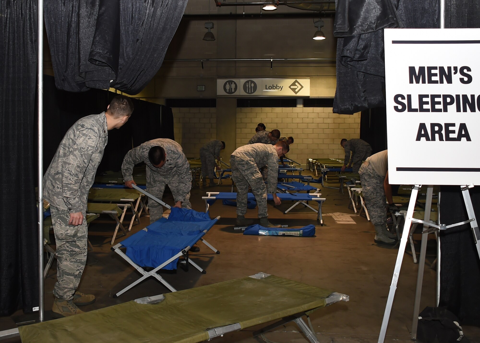 Volunteers from the Space and Missile Systems Center at Los Angeles Air Force Base in El Segundo, Calif. set up sleeping cots inside the Los Angeles Convention Center Dec. 18, 2015 prior to the start of the 2nd annual L.A. Vets Stand Down. More than 65 volunteers from SMC joined dozens of service providers from federal, state, city and county governments as well as local nonprofit partners from across Los Angeles County and the South Bay during the three-day event, billed as the largest stand down for homeless military veterans and their families to ever take place in the country. (U.S. Air Force photo/Sarah Corrice)