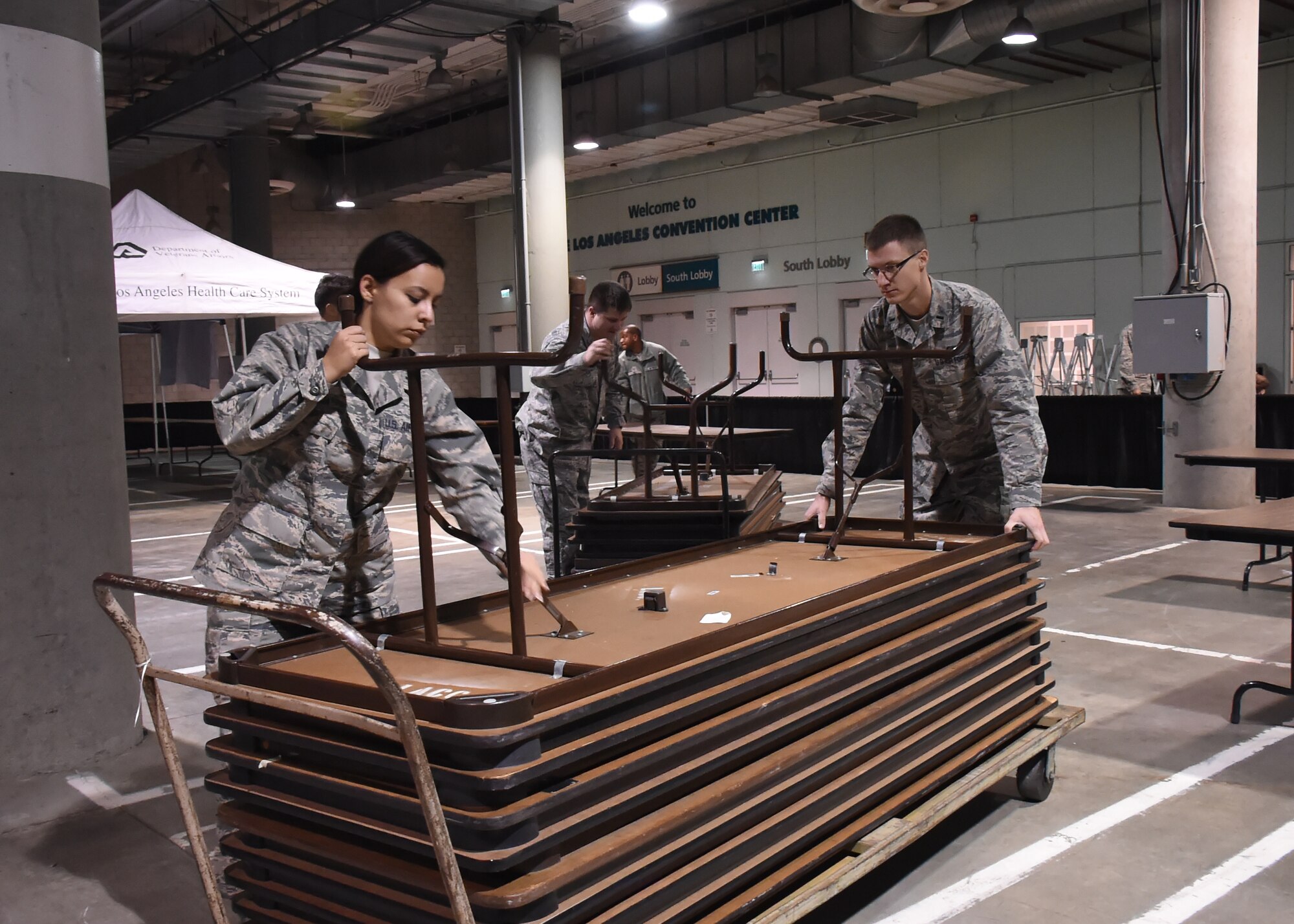 Volunteers from the Space and Missile Systems Center at Los Angeles Air Force Base in El Segundo, Calif. set up tables inside the Los Angeles Convention Center Dec. 18, 2015 prior to the start of the 2nd annual L.A. Vets Stand Down. More than 65 volunteers from SMC joined dozens of service providers from federal, state, city and county governments as well as local nonprofit partners from across Los Angeles County and the South Bay during the three-day event, billed as the largest stand down for homeless military veterans and their families to ever take place in the country. (U.S. Air Force photo/Sarah Corrice)