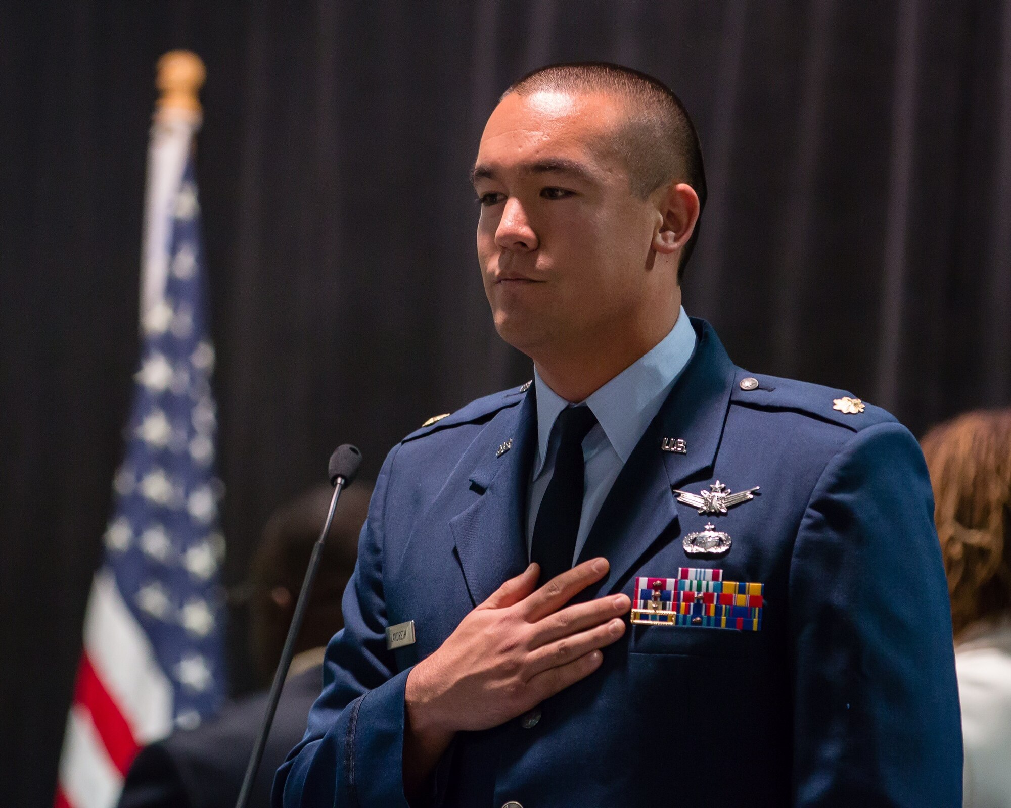 Maj. Dex Landreth, Evolved Expendable Launch Vehicle Mission Integration chief with the Space and Missile Systems Center’s Launch Systems Enterprise Directorate leads the audience in the pledge of allegiance ceremony during the 2nd annual L.A. Vets Stand Down. Maj. Landreth’s involvement as SMC project officer and volunteer coordinator in the stand down stems from a nine-month fellowship that brought him to the attention of United States Veterans Initiatives, a private non-profit organization that provides housing, employment, and counseling to veterans. (U.S. Air Force photo/Lt. Col. Chris Troyer)
