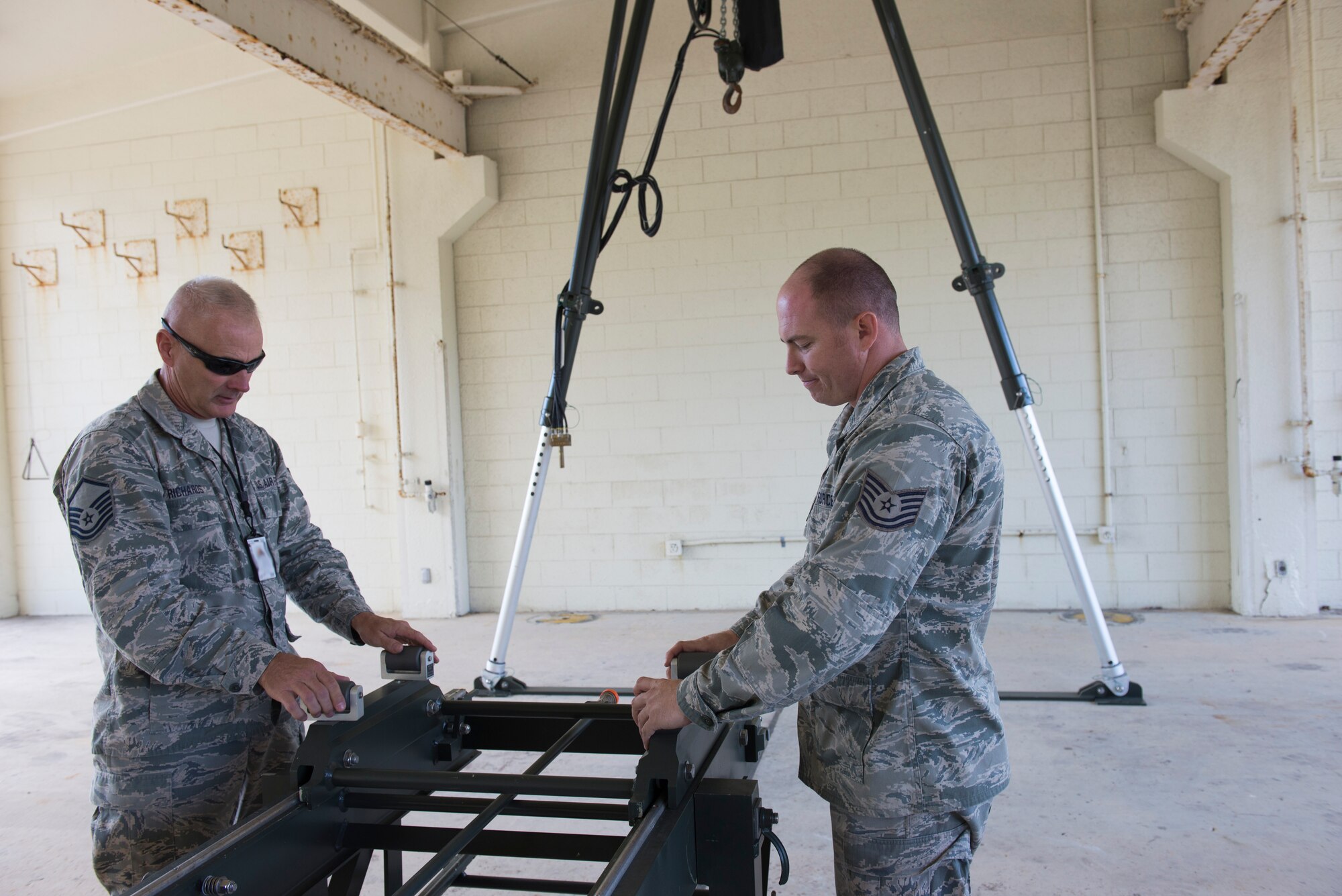 U.S. Air Force Master Sgt. Jim Richards, 138th Fighter Wing maintenance superintendent, and Tech. Sgt. Randy Mortan, 138th Fighter Wing NCO in charge of conventional maintenance, display a mobile assembly kit used to build bombs, Dec. 18, 2015, at Kadena Air Base, Japan. The 138th Fighter Wing’s Air National Guardsmen practiced alongside their active duty counterparts from the 18th Munitions Squadron building air-to-ground munitions. (U.S. Air Force photo by Senior Airman Omari Bernard)