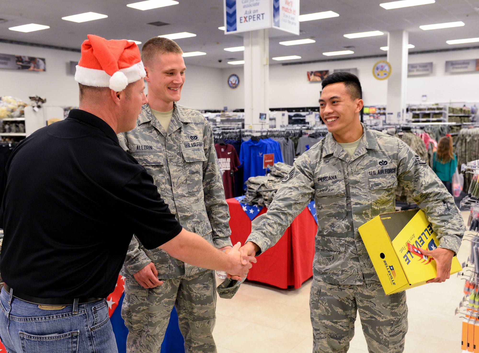 U.S. Air Force Staff Sgt. Made Perdana, 18th Civil Engineer Squadron water and fuels maintenance craftsman, smiles after Chief Master Sgt. Charles Hoffman, 18th Wing command chief, offers to pay for a new pair of boots, Dec. 21, 2015, at the Base Exchange, Kadena Air Base, Japan. Hoffman was helping the Okinawa Enlisted Spouses’ Club distribute random acts of kindness to enlisted families during the holiday season. Funds for RAOK have been raised throughout the year by the OESC’s non-profit thrift stores, located on various military installations. (U.S. Air Force photo by Senior Airman John Linzmeier)