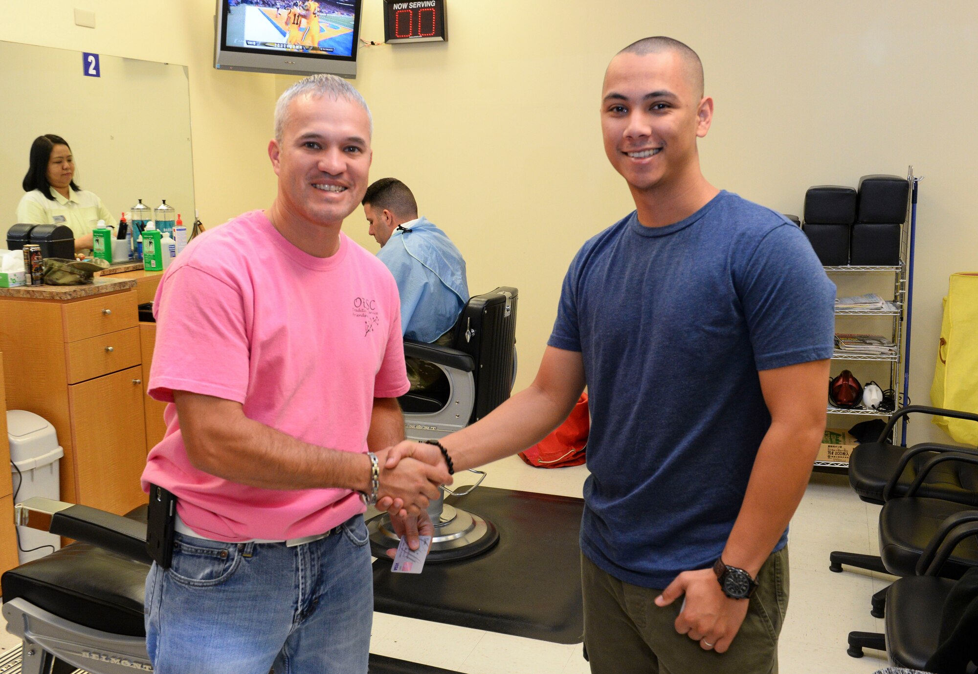 Victor Colon, Okinawa Enlisted Spouses’ Club vice president, offered to pay for haircuts to patrons such as U.S. Air Force Senior Airman Don Sherman, 733rd Air Mobility Squadron passenger service agent, at the Olympic Mall barber shop, Dec. 28, 2015, at Kadena Air Base, Japan. Volunteers from the OESC visited various military installations on island, offering to purchase simple things such as a haircuts, meals, tanks of gas or even a cart full of groceries for enlisted members from all U.S. branches service. (U.S. Air Force photo by Senior Airman John Linzmeier)