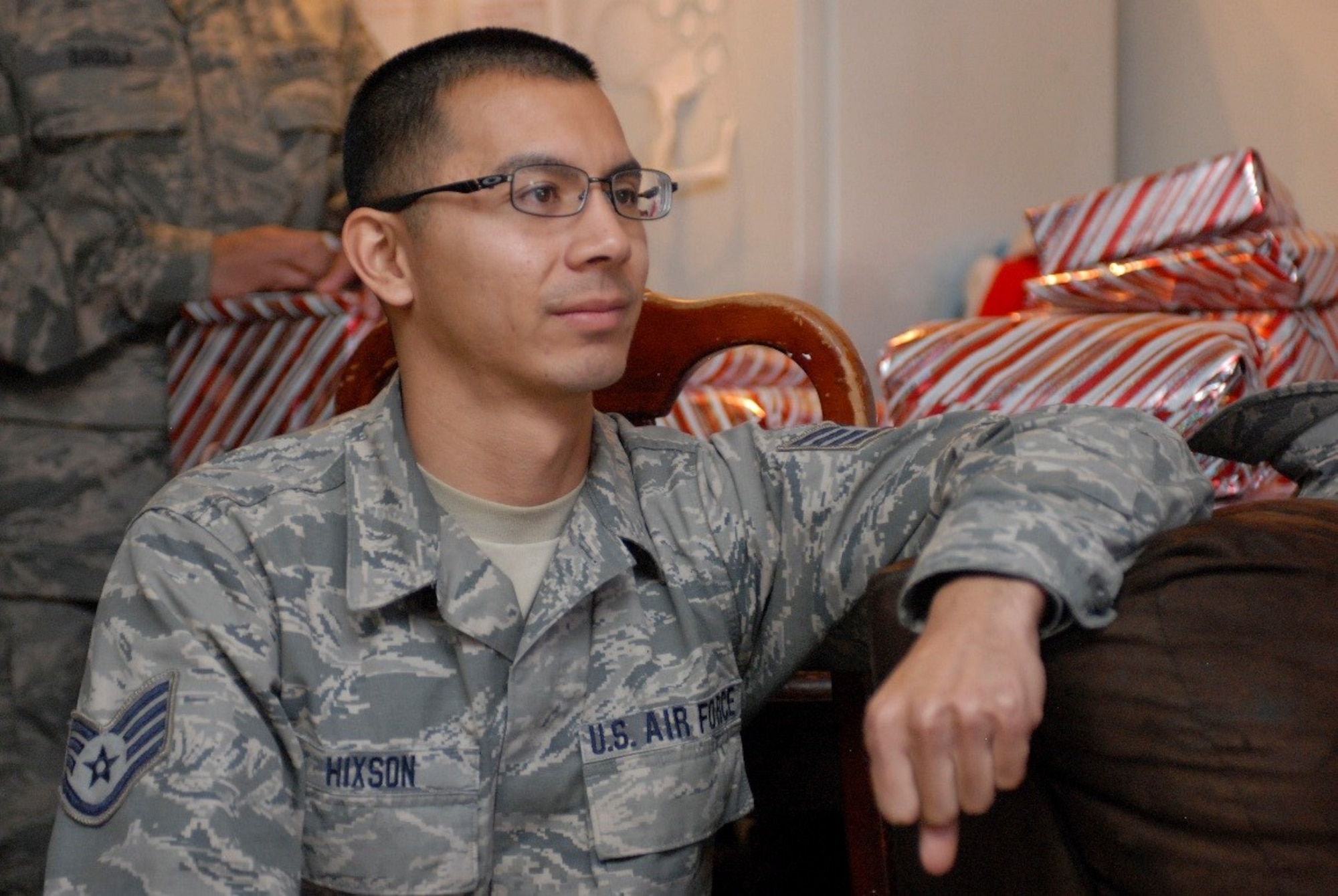 Airmen of the 162nd Wing Arizona Air National Guard’s Aerospace Ground Equipment shop delivered holiday cheer to a deserving family this year.  Staff Sgt. Victor Hixson listens intently while the four children sing “God Bless the USA” to thank the Airmen for their service to the nation and their support this holiday season. (U.S. Air National Guard Photo by 2nd Lt. Lacey Roberts)