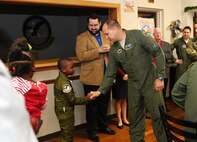 Derrick James, 8-year-old Pilot for a Day participant, shakes hands with Col. John Nichols, 14th Flying Training Wing Commander, after receiving his flight suit and having his patches pinned on by Nichols Dec. 22 at Columbus Air Force Base, Mississippi. During the day, James and his family learned about the base’s mission, visited static aircraft displays, toured various units and ended the day “flying” in a T-6 Texan II simulator. (U.S. Air Force photo/Senior Airman Kaleb Snay)