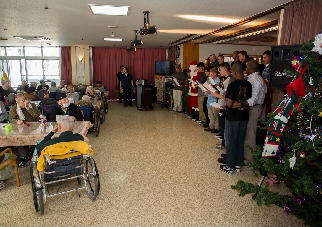 Marines with 7th Communication Battalion sing Christmas carols to residents of Hikariga Oka Nursing Home during a Christmas party at HikarigaOka Nursing Home in Kin Town, Okinawa, Japan, Dec. 18, 2015. The nursing home hosts the party annually as thanks for the Marines' continuous contributions to the home. Since 1994, Marines with the battalion have regularly volunteered to help maintain the home’s grounds of the home and spend time with the residents. The Marines are with various units under 7th Comm. Bn., III Marine Expeditionary Force Headquarters Group, III MEF. (U.S. Marine Corps Photo by Cpl. Devon Tindle/Released)