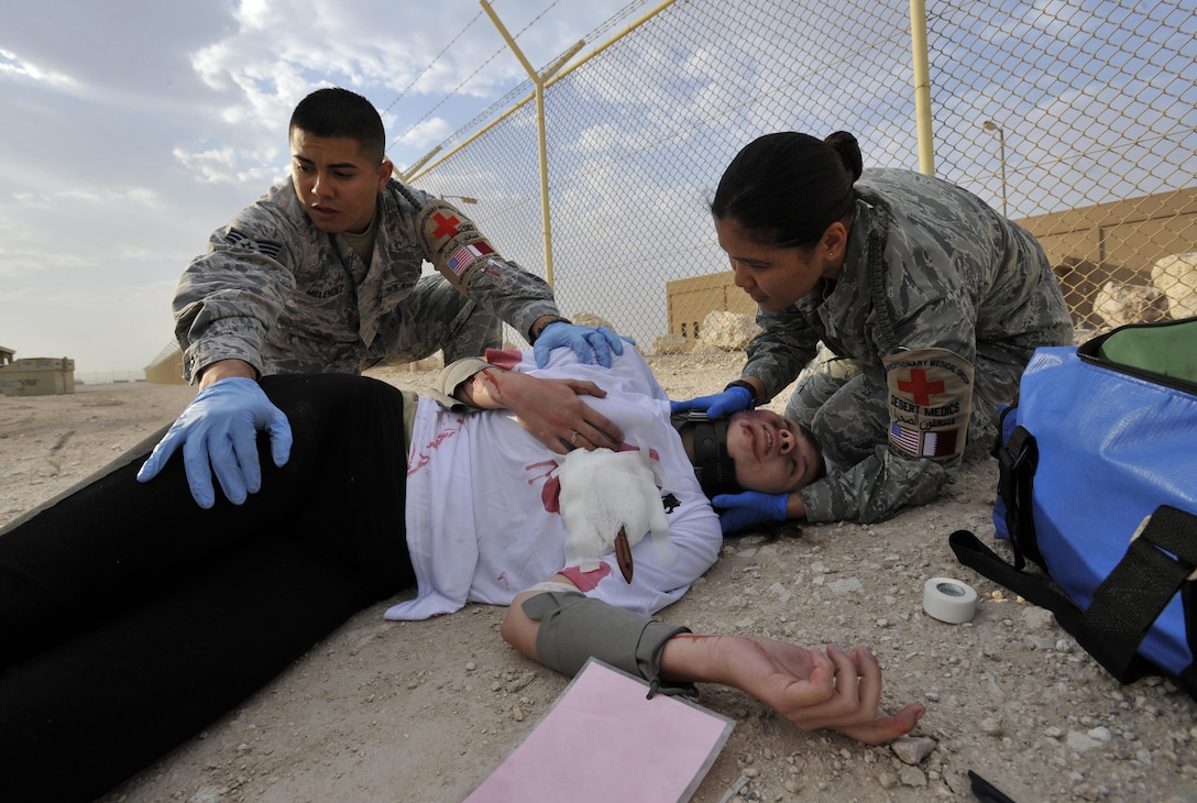 U.S. Air Force Senior Airman Marco Melendez, left, and U.S. Air Force Staff Sgt. Mary Lynn Llaguno roll a simulated patient to her back during a mass casualty exercise on Al Udeid Air Base, Qatar, Dec. 15, 2015. Melendez and Llaguno are assigned to the 379th Expeditionary Medical Operations Squadron. U.S. Air Force photo by Master Sgt. Joshua Strang