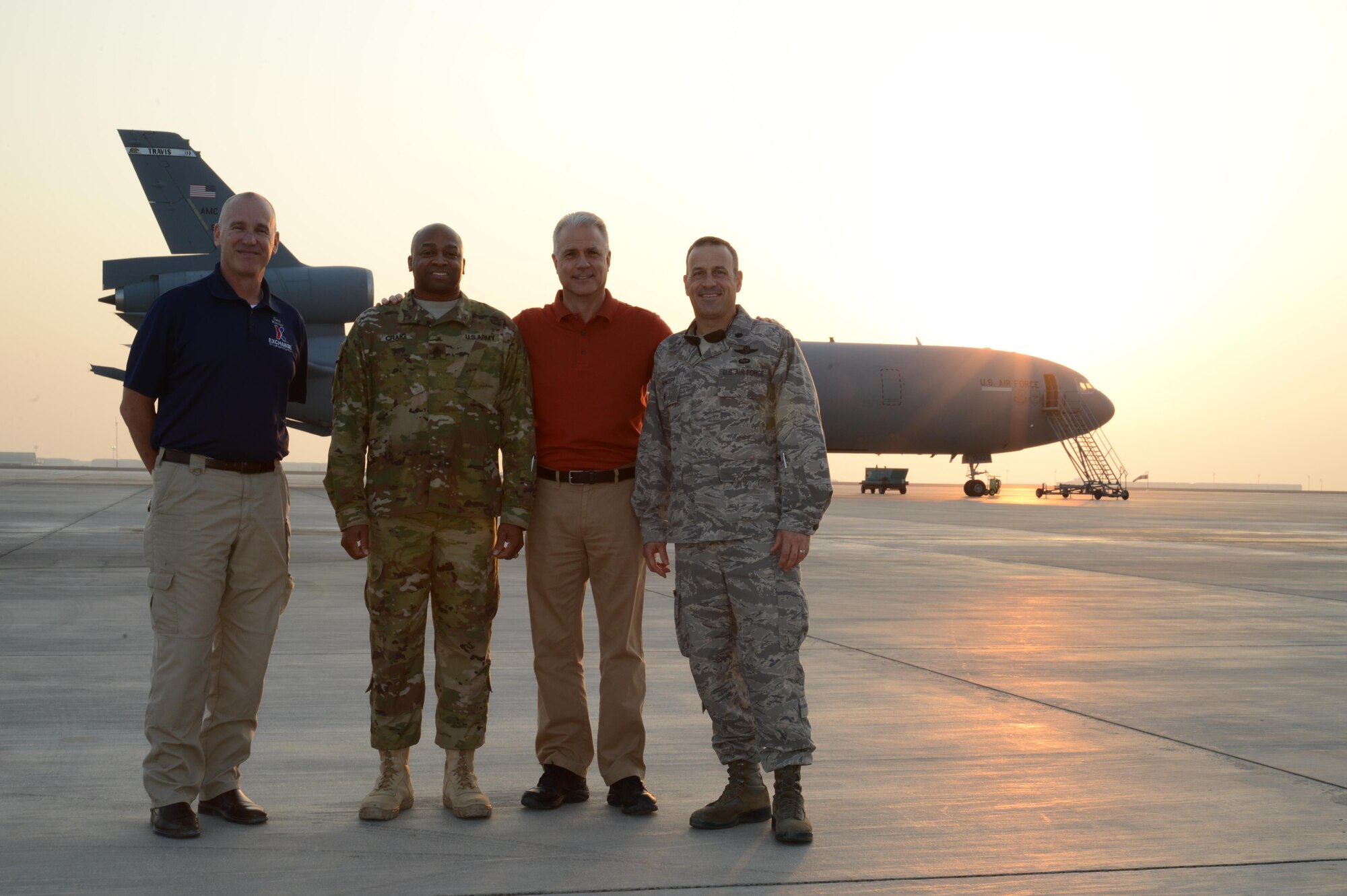 Ken Caldwell, senior vice president and general sales manager for theatrical sales and distribution, North America, Walt Disney Studios Motion Pictures, poses for a photo in front of a KC-10 Extender with Army and Air Force Exchange Service and 380th Air Expeditionary Wing representatives at an undisclosed location, Dec. 21, 2015. Disney and AAFES coordinated their efforts to ensure deployed service members were able to see the movie before returning home. (U. S. Air Force photo by Tech. Sgt. Frank Miller/Released)