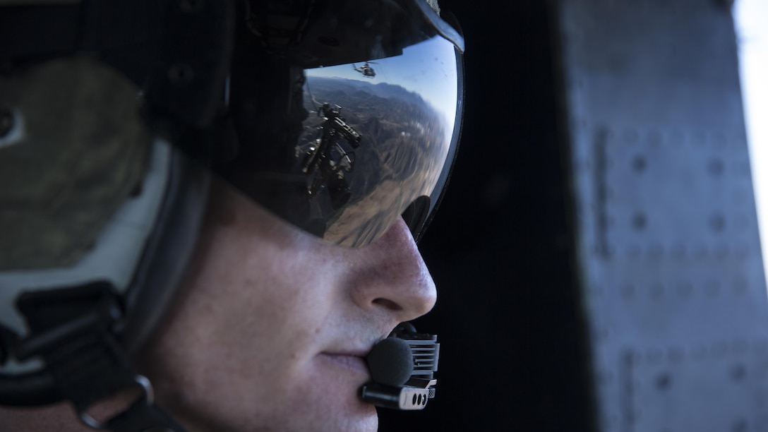 Gunnery Sgt. Christopher Mulcahy, a combat marksmanship trainer instructor with Marine Light Attack Helicopter Training Squadron 303, looks out of a UH-1Y Huey during a formation flight above Marine Corps Base Camp Pendleton, California, Dec. 17. Mulcahy communicated the position of another Huey and other aircraft during the formation flight.