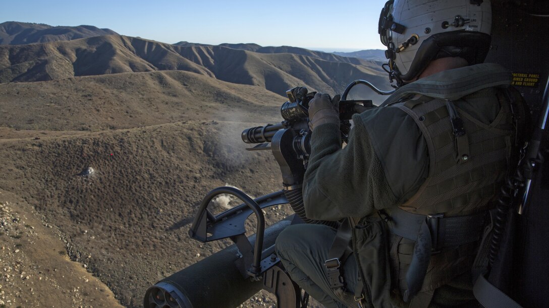 Gunnery Sgt. Christopher Mulcahy, a combat marksmanship trainer instructor with Marine Light Attack Helicopter Training Squadron 303, fires an M134 GAU-17 Minigun during an aerial gunnery shoot at Marine Corps Base Camp Pendleton, California, Dec. 17. Marines with HMLAT-303 flew a formation flight and conducted an aerial gunnery to shoot give students the opportunity to refine basic skills needed to operate in the Fleet Marine Force.