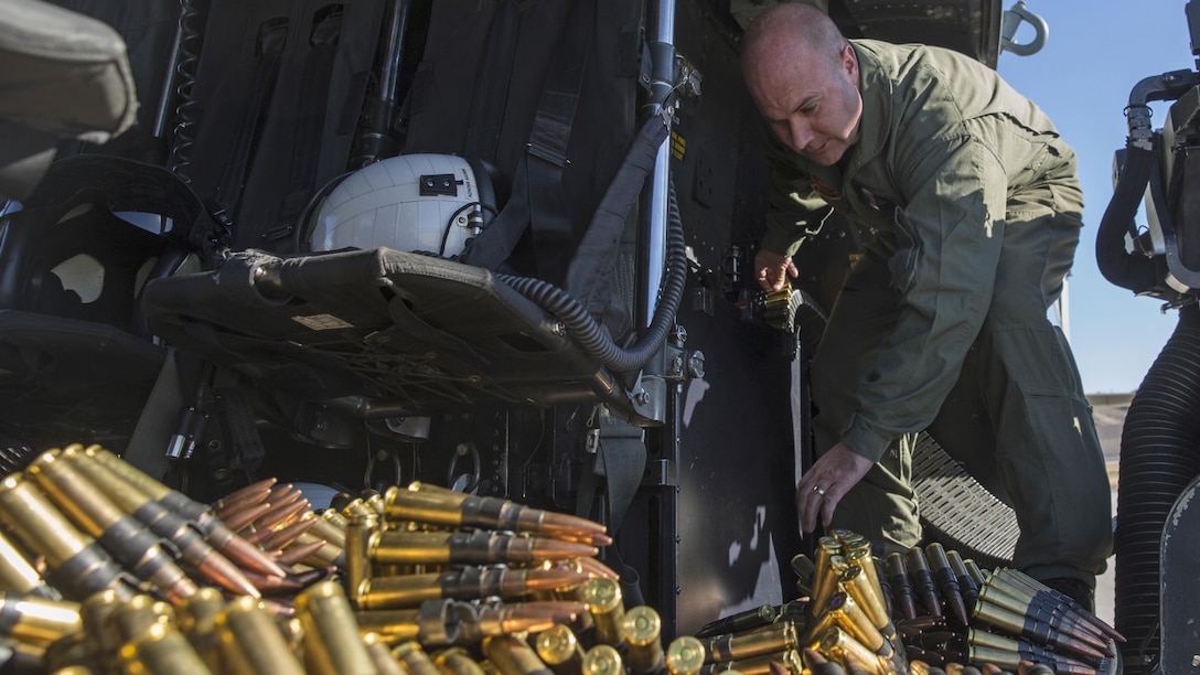 Staff Sgt. Gregory Westhoff, a combat marksmanship trainer instructor with Marine Light Attack Helicopter Training Squadron 303, prepares the .50 caliber machine gun ammunition for an aerial gunnery shoot at Marine Corps Air Station Camp Pendleton, California, Dec. 17. Marines with HMLAT-303 flew a formation flight and conducted an aerial gunnery to shoot to give students the opportunity to refine basic skills needed to operate in the Fleet Marine Force.
