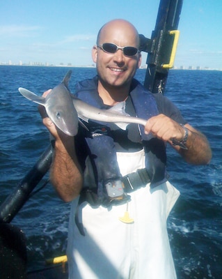 Robert Smith, a biologist with the U.S. Army Corps of Engineers, New York District, holds a dogfish (a small shark) offshore of the Rockaways in Queens, NY, in 2013.