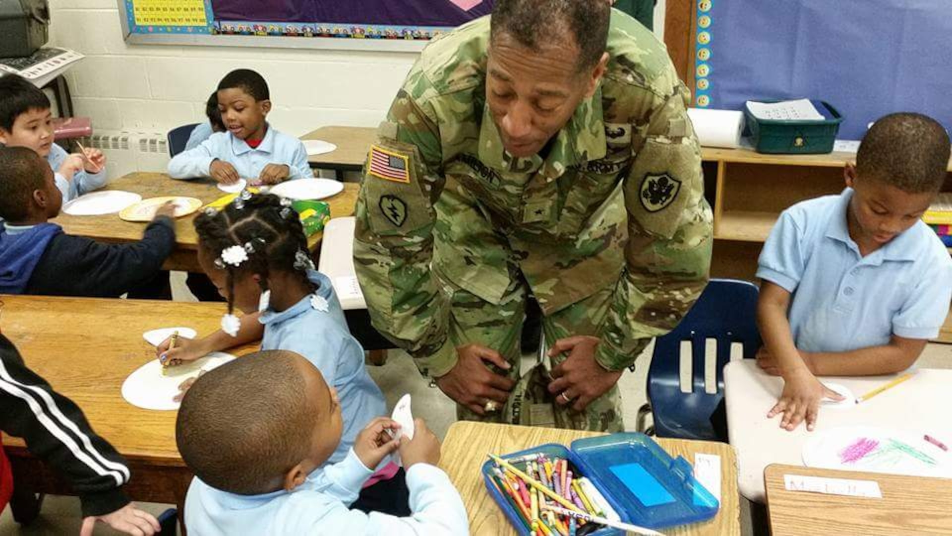 DLA Troop Support Commander Army Brig. Gen. Charles Hamilton greets students at Benjamin Franklin Elementary School during the organization’s annual children’s holiday party Dec. 10, 2015. More than 200 kindergarteners and first-graders participated in arts and crafts, games and received gifts donated by DLA Troop Support employees.