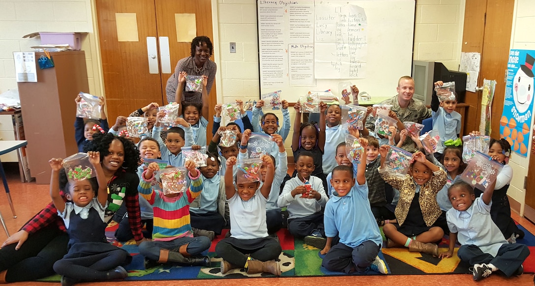 Students from Benjamin Franklin Elementary School and DLA Troop Support employees hold up crafts made during the organization’s annual children’s holiday party Dec. 10, 2015. Employee volunteers led the party activities in addition to collecting, wrapping and transporting approximately 600 presents. Courtesy photo 