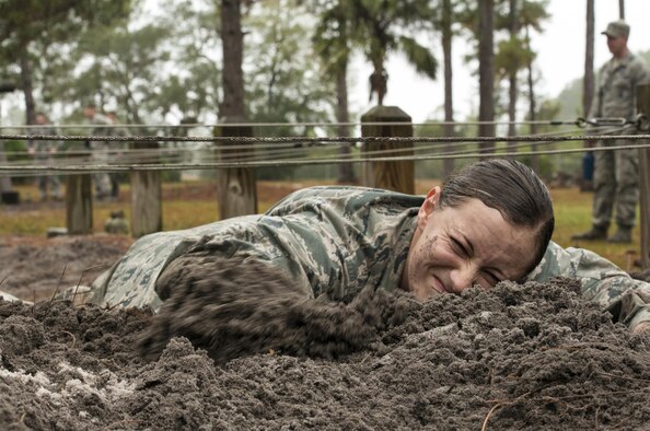 Second Lt. Lizette Wu, assigned to the 820th Base Defense Group, low crawls through mud as part of an obstacle course during an air assault assessment Dec. 15, 2015, at Camp Blanding, Fla. Airmen had to crawl without letting any part of their body touch the metal wires hung above. (U.S. Air Force photo/Airman 1st Class Lauren M. Johnson) 