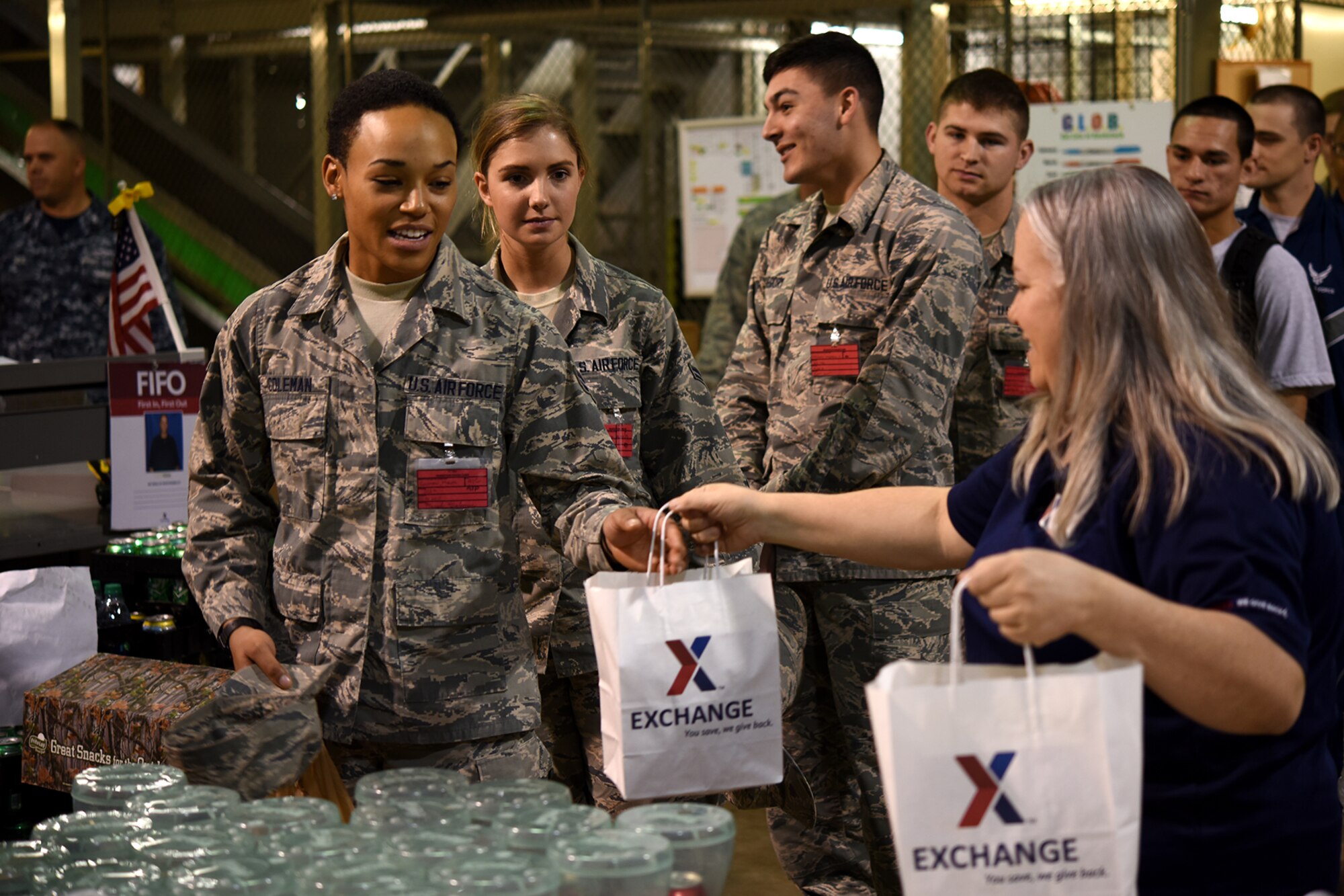 Lisa A. Piper, Army and Air Force Exchange Service assistant manager, right, hands a gift bag to U.S. Air Force Airman 1st Class Moriah E. Coleman, 312th Training Squadron student, left, at the Exchange on Goodfellow Air Force Base, Texas, Dec. 23, 2015. The gift bags were handed out to single permanent party and student service members who stayed local for the holidays. (U.S. Air Force photo by Senior Airman Devin Boyer/Released)