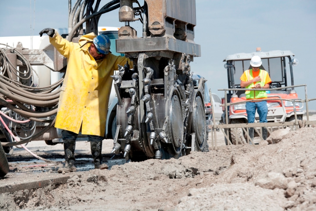 A worker directs a "hydro-mill" into position while installing a partial cutoff wall in the Herbert Hoover Dike.  The cutoff wall was installed in 21.4 miles of the dike from 2007-2013 to help reduce seepage through the earthen dam as part of a major rehabilitation project.