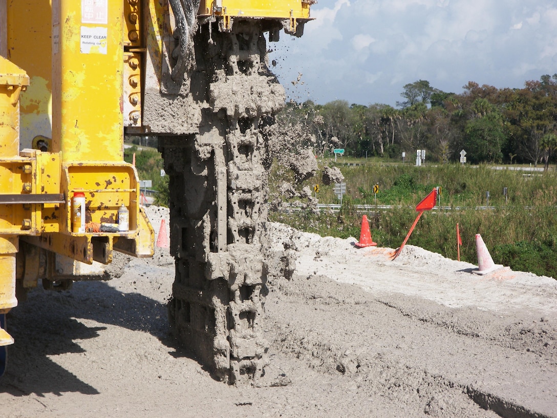 The mud flies as machine functioning as a "vertical chain saw" mixes soil with slurry to form a partial cutoff wall in the Herbert Hoover Dike surround Lake Okeechobee in south Florida.  The work was part of a $220 million investment to reduce the risk of dike failure through installation of 21.4 miles of cutoff wall on the southeast side of the dike.