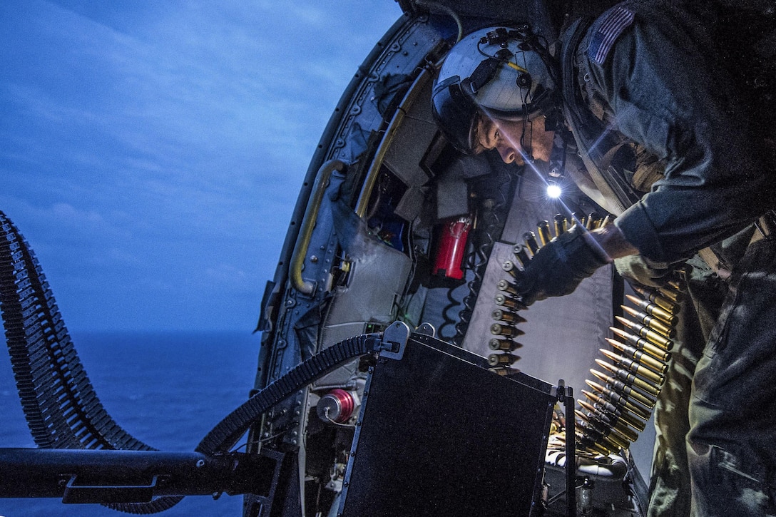 U.S. Navy Petty Officer 2nd Class Blake Werner prepares a .50-caliber machine gun aboard an MH-60R Seahawk helicopter over the South China Sea, Dec. 19, 2015. Werner is a naval aircrewman tactical helicopter. The Seahawk is assigned to the USS Fort Worth, which is on a rotational deployment to support the U.S. rebalance to the Asia-Pacific region. U.S. Navy photo by Petty Officer 2nd Class Antonio Turretto Ramos