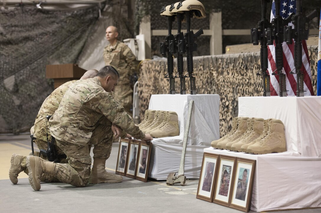 U.S. service members pay their respects during a ceremony on Bagram Airfield, Afghanistan, Dec. 23, 2015, to honor six airmen killed in a vehicle bomb attack on their patrol outside Bagram. U.S. Air Force photo by Tech. Sgt. Robert Cloys
