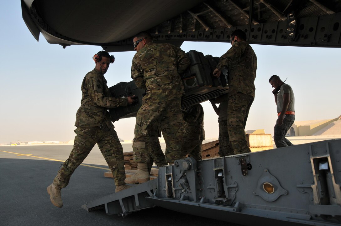 U.S. soldiers offload cargo from a C-17 Globemaster aircraft on Al Udeid Air Base, Qatar, Dec. 13, 2015. U.S. Air Force photo by Tech. Sgt. Terrica Y. Jones