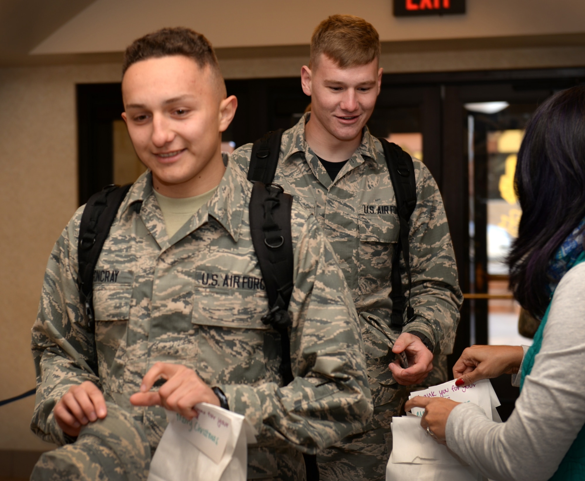 Airmen in Training in the 364th Training Squadron receive their bags of cookies from members of the Key Spouses organization on Dec. 18, 2015, as they return to their dorm to prepare for the holiday Exodus. (U.S. Air Force photo/2nd Lt. Brittany Curry)