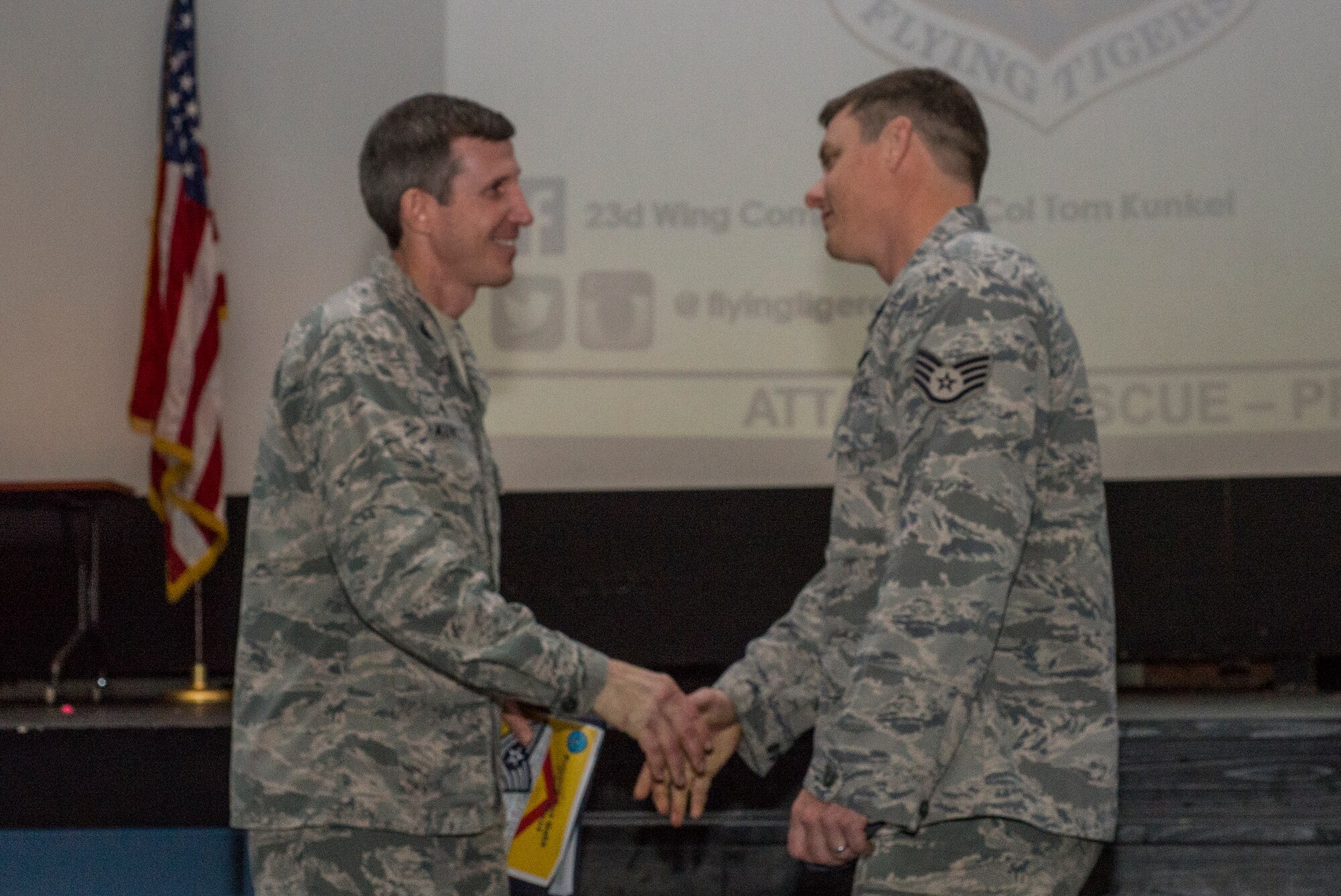 U.S. Air Force Col. Thomas Kunkel, 23d Wing commander, shakes hands with Staff Sgt. Brent Slyter, 71st Rescue Squadron, after he was promoted under the Stripes for Exceptional Performers program, Dec. 23, 2015, at Moody Air Force Base, Ga. Each year, the Air Force releases a limited number of stripes under the STEP promotion program and this year 23d Wg leadership presented two Airmen with a new stripe. (U.S. Air Force photo by Airman Daniel Snider/Released)