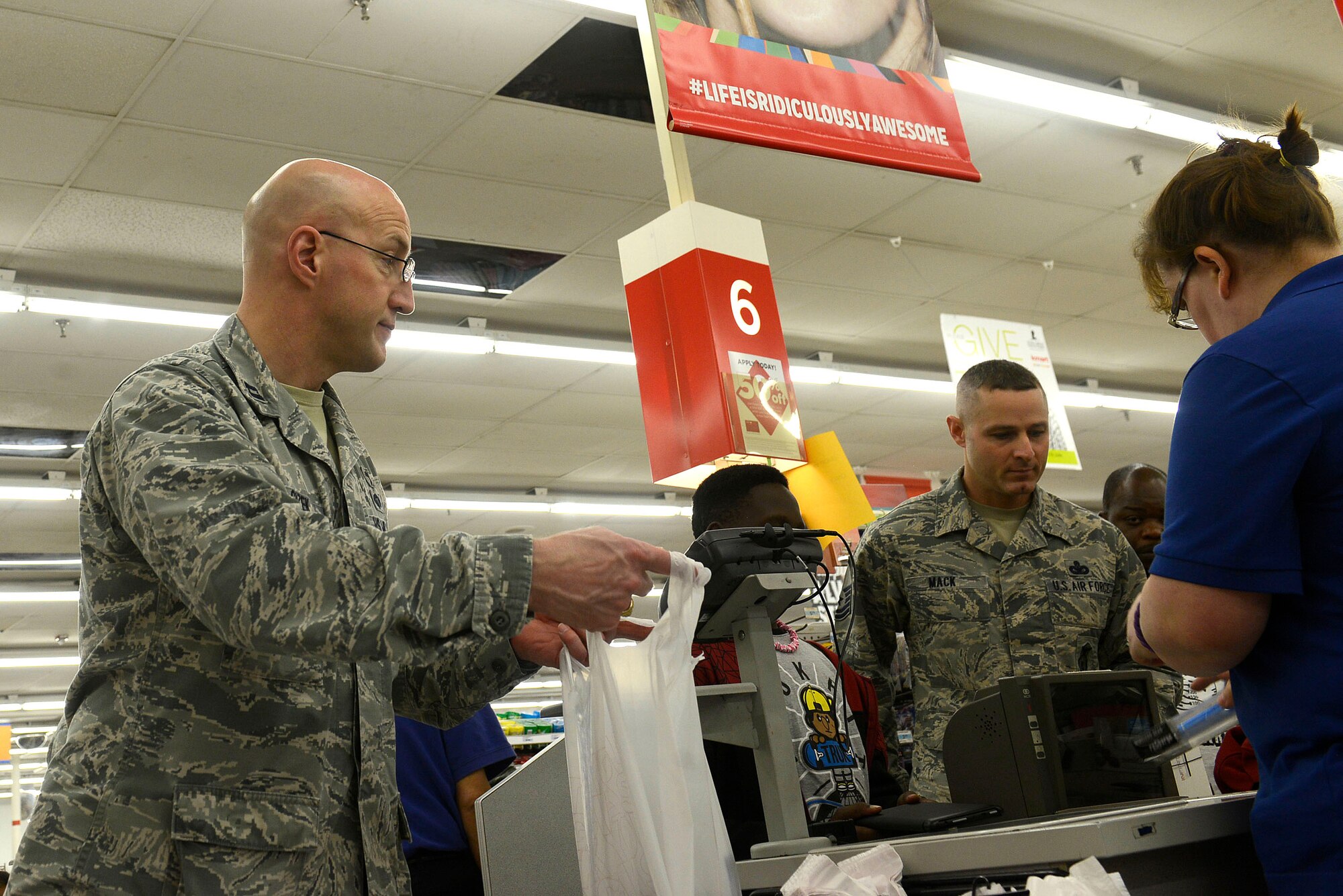 U.S. Air Force Chaplain (Capt.) Curt Cizek, 20th Fighter Wing chaplain, bags gifts during a Shop with a Cop event at a local store in Sumter, S.C., Dec. 21, 2015. Chaplain Cizek accompanied children from the John K. Crosswell Home for Children, Sumter, S.C., and 20th Security Forces Squadron Airmen as they went Christmas shopping for toys and clothing. (U.S. Air Force photo by Airman 1st Class Christopher Maldonado)