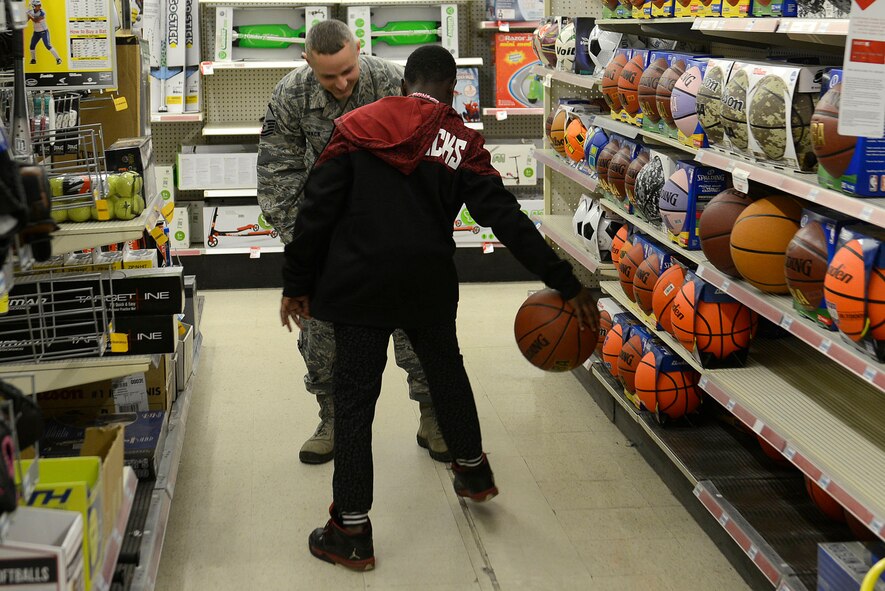 U.S. Air Force Master Sgt. Robert Mack, 20th Security Forces Squadron flight sergeant, plays basketball with a child from the John K. Crosswell Home for Children, Sumter, S.C., during a Shop with a Cop event at a local store in Sumter, Dec. 21, 2015. Shop with a Cop is the second annual event held by the Airmen assigned to the 20th SFS. (U.S. Air Force photo by Airman 1st Class Christopher Maldonado)