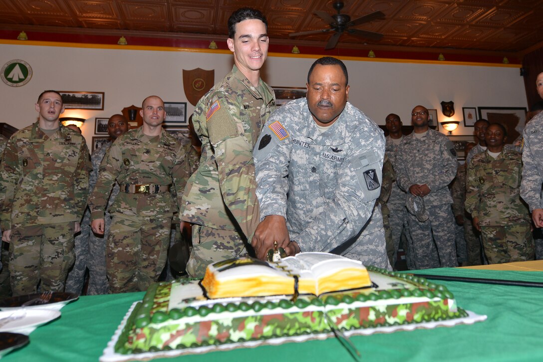U.S. Army Sgt. Maj. Keith Hunter, a senior training developer assigned to the 128th Aviation Brigade, right, and Sgt. Robert Trommer, a forklift operator for the 359th Inland Cargo Transfer Company, cut the U.S. Army noncommissioned officer Corps’ birthday cake at Fort Eustis, Va., Dec. 15, 2015. It is tradition for the eldest and youngest member in attendance to cut the cake. (U.S. Air Force photo by Staff Sgt. Natasha Stannard)