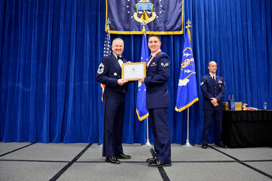 MCGHEE TYSON AIR NATIONAL GUARD BASE, Tenn. -  Senior Airman Johnathan Budnick, right, receives the Distinguished Graduate Award for Airman leadership school class 16-2 from Chief Master Sgt. Kevin Thomas, Air National Guard advisor to the commander, Thomas N. Barnes Center for Enlisted Education, here, Dec. 17, 2015, at the I. G. Brown Training and Education Center. The distinguished graduate award is presented to students in the top 10 percent of the class.(U.S. Air National Guard photo by Master Sgt. Jerry D. Harlan/Released)