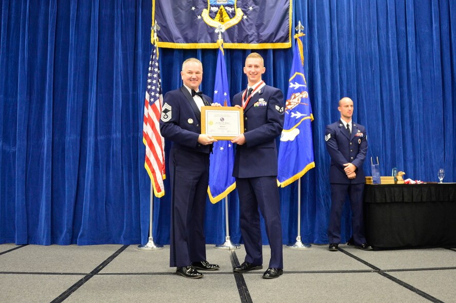 MCGHEE TYSON AIR NATIONAL GUARD BASE, Tenn. -  Senior Airman Bryce Hebert, right, receives the Distinguished Graduate Award for Airman leadership school class 16-2 from Chief Master Sgt. Kevin Thomas, Air National Guard advisor to the commander, Thomas N. Barnes Center for Enlisted Education, here, Dec. 17, 2015, at the I. G. Brown Training and Education Center. The distinguished graduate award is presented to students in the top 10 percent of the class.(U.S. Air National Guard photo by Master Sgt. Jerry D. Harlan/Released)