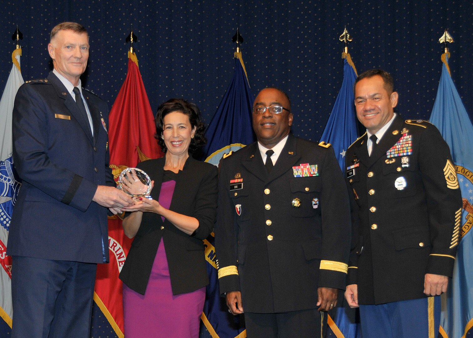 DLA director Air Force Lt. Gen. Andy Busch, left, presents Eva Maria Perez Sanchez, administrative support assistant at Distribution Sigonella, Italy, with the Top 10 Employee award at the 48th annual employee recognition ceremony Dec. 10. Distribution’s commander Army Brig. Gen. Richard Dix, second from right, and DLA’s Senior Enlisted Leader Army Command Sgt. Maj. Charles Tobin, right, were also on-hand to present the award. 