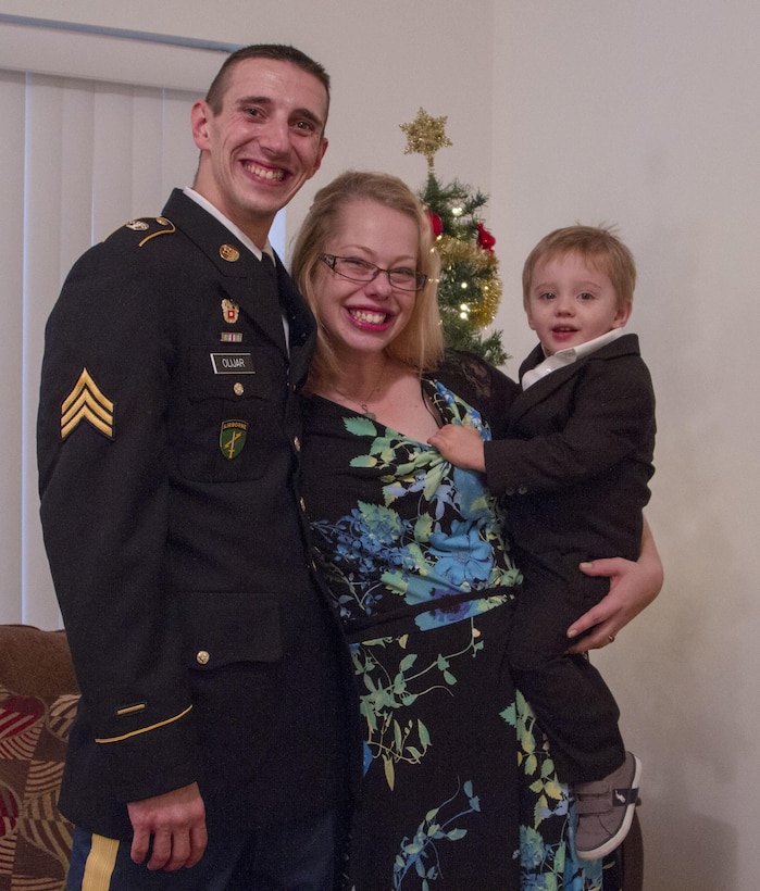 Sgt. Scott Olijar, his wife, Jennifer, and their son pose in front of their Christmas tree at their donated condominium on December 23, 2015. Through a partnership with the Illinois Housing Development Authority (IHDA) and the city of Berwyn, the Olijars received a fully furnished, permanent new home. (U.S. Army photo by Sgt. Elizabeth Barlow/Released)