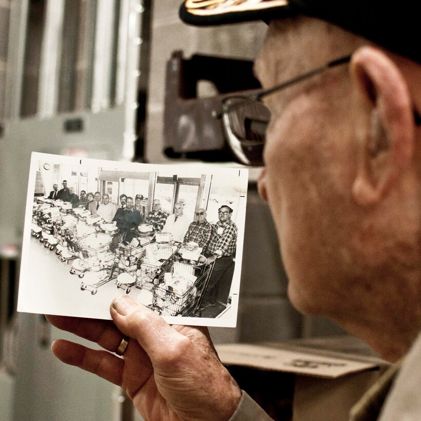 Retired Marine Corps Col. Frank Harris of Manassas, Virginia, shares a 20-year-old photo of the National Sojourners Quantico Chapter 44 members’ Christmas Food Basket program at the Quantico Marine Corps Base Commissary aboard Marine Corps Base Quantico.