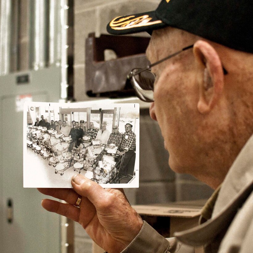 Retired Marine Corps Col. Frank Harris of Manassas, Virginia, shares a 20-year-old photo of the National Sojourners Quantico Chapter 44 members’ Christmas Food Basket program at the Quantico Marine Corps Base Commissary aboard Marine Corps Base Quantico.