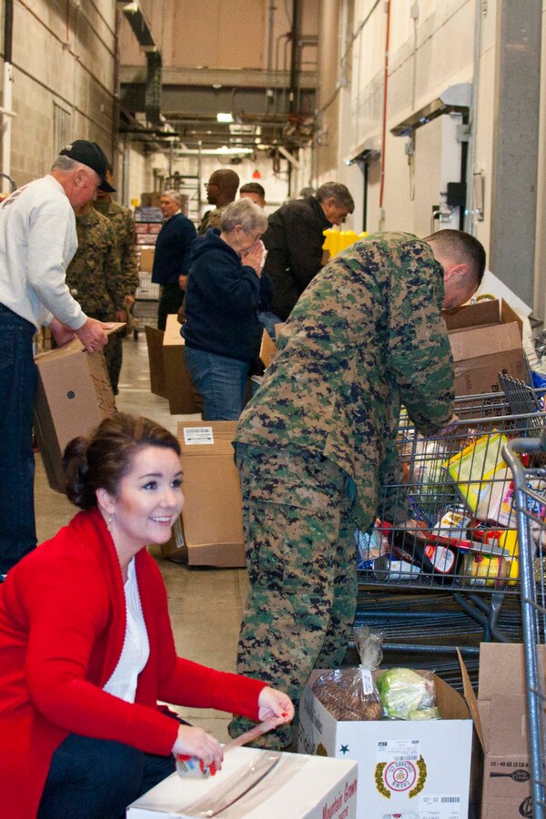 Stephanie Taber, Family Readiness program trainer and Col. Joseph Murray, base commander, join 17 members of the National Sojourners Quantico Chapter 44 during their annual Christmas Food Basket program at the Quantico Marine Corps Base Commissary aboard Marine Corps Base Quantico.