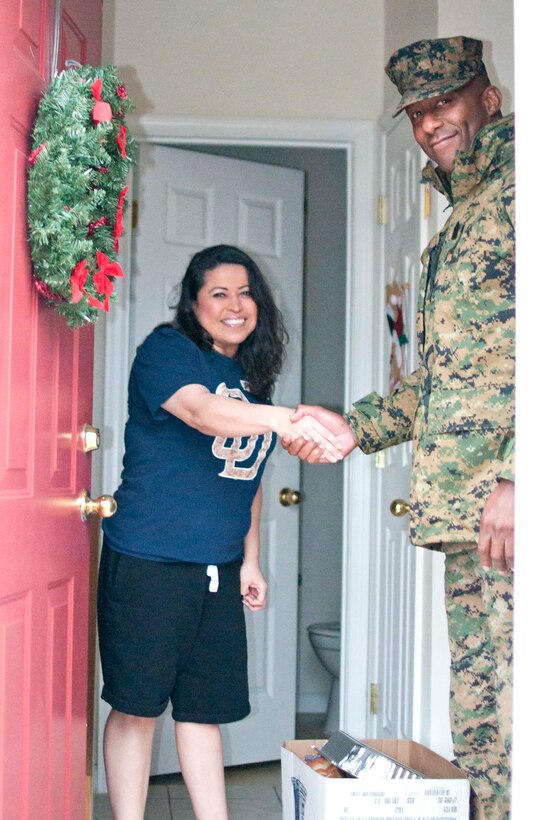 Sgt. Maj. Gerald Saunders, base sergeant major, delivers a food basket to Anna Tillman, military spouse of an active duty Marine, aboard Marine Corps Base Quantico, Dec. 22. The National Sojourners Quantico Chapter’s 44 members donated 35 Christmas Food Baskets with the help of active duty Marines, the Family Readiness Program and the Quantico Marine Corps Base Commissary staff.