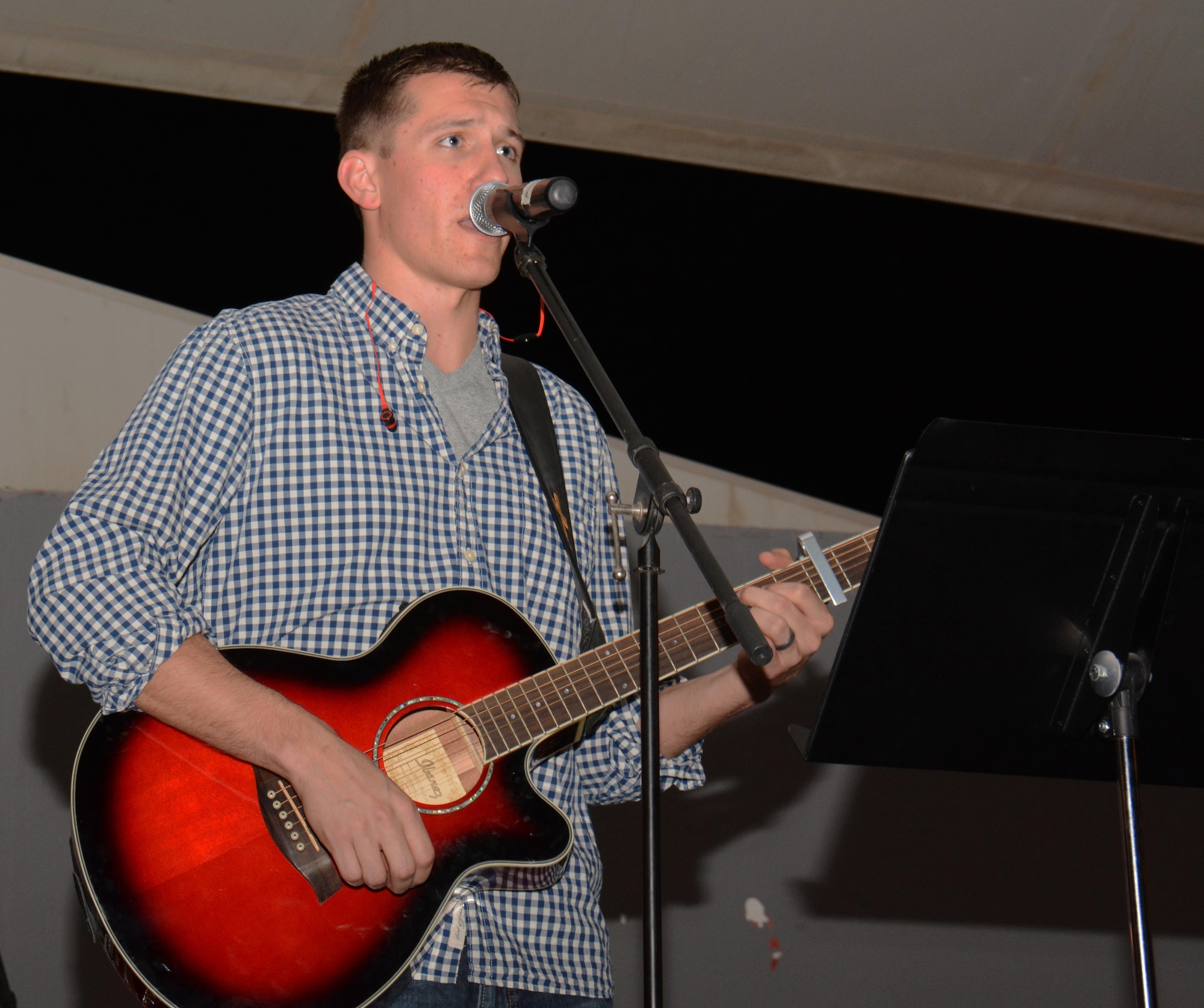 1st Lt. Kevin Stoll, U.S. Air Force’s Central Operations Directorate and lead singer for the Protestant Praise Team, sings and plays the guitar during a performance at the Christmas at the Plaza concert at Al Udeid Air Base, Qatar Dec. 23. Stoll has played the guitar for eight years and said he enjoys using music to lift people’s spirits. The concert featured numerous holiday favorites including “Hark the Herald Angels Sing.” (U.S. Air Force photo by Tech. Sgt. James Hodgman/Released)