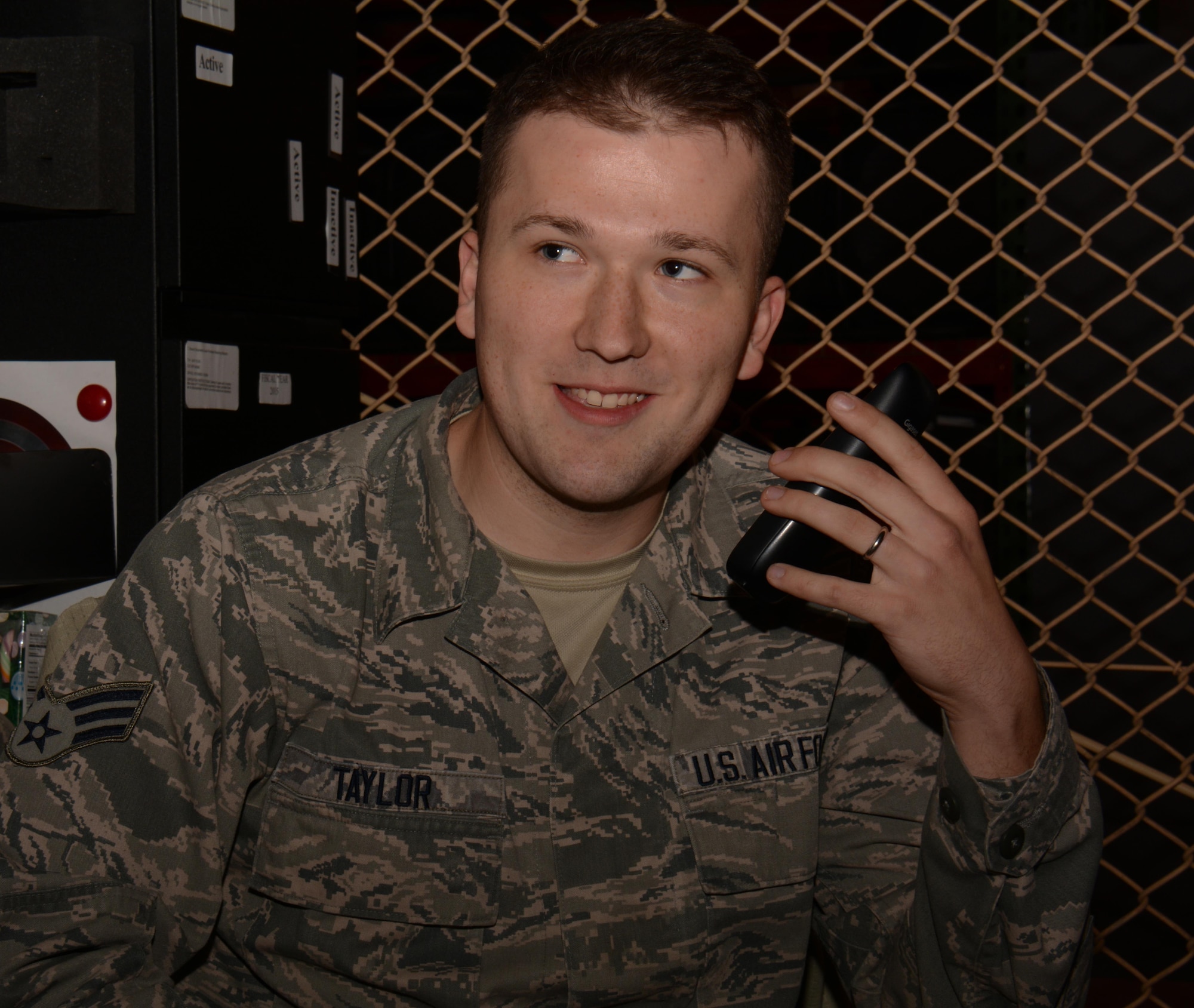 Senior Airman Christopher Taylor, 379th Expeditionary Medical Group medical logistician from Hendersonville, Tennessee, speaks to Secretary of the Air Force, Deborah Lee James, over the phone at Al Udeid Air Base, Qatar Dec. 24. James telephoned several airmen to wish them a happy holiday and to express her appreciation for their service. Taylor was the only airman at AUAB to receive the honor and said he’s thankful for such a rare opportunity. (U.S. Air Force photo by Tech. Sgt. James Hodgman/Released)