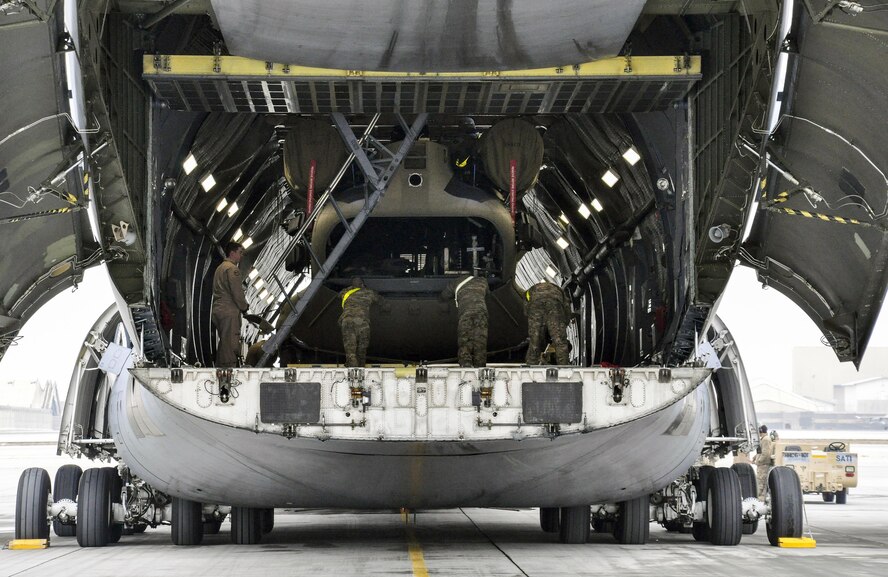 Soldiers from Task Force Destiny pair with Airmen from 9th Airlift Squadron, Dover Air Force Base, Del., to unload a helicopter from a C-5M Super Galaxy at Bagram Airfield, Afghanistan Dec. 26, 2015. The C-5M is the largest military transport aircraft in the world, capable of hauling 270,000 pounds of cargo. (U.S. Air Force photo by Tech. Sgt. Nicholas Rau)