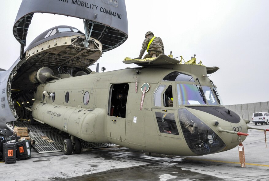 Soldiers from Task Force Destiny pair with Airmen from 9th Airlift Squadron, Dover Air Force Base, Del., to unload a helicopter from a C-5M Super Galaxy at Bagram Airfield, Afghanistan Dec. 26, 2015. The C-5M is the largest military transport aircraft in the world, capable of hauling 270,000 pounds of cargo. (U.S. Air Force photo by Tech. Sgt. Nicholas Rau)