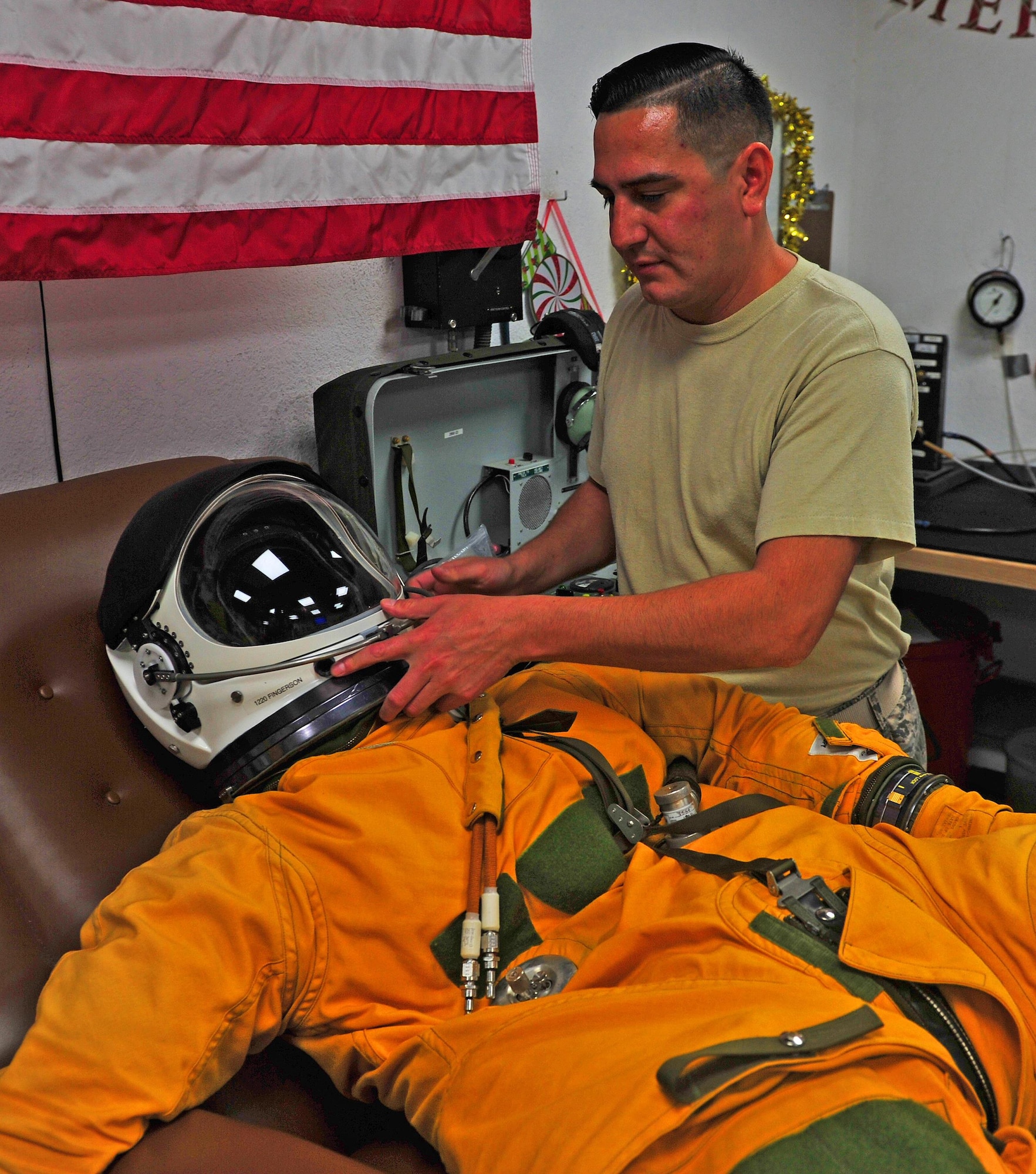 Tech. Sgt. Aaron, 99th Expeditionary Reconnaissance Squadron NCO in charge, inspects a full-pressure suit at an undisclosed location in Southwest Asia, Dec. 22, 2015. Full-pressure suits are bright yellow garments, averaging approximately 250,000 dollars, which allow pilots to survive at elevations of over 70,000 feet. (U.S. Air Force photo by Staff Sgt. Kentavist P. Brackin/released)