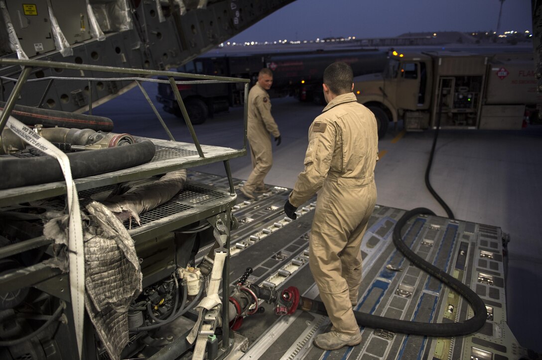 U.S. Air Force Senior Airmen Dalton Lobato, right, and Benjamin Hunter fill fuel bladders for transport to support Operation Inherent Resolve coalition bases in Iraq from Al Udeid Air Base, Qatar, Dec. 16, 2015. Lobato and Hunter are aerial bulk fuels delivery system team members assigned to the 379th Expeditionary Logistics Readiness Squadron. U.S. Air Force photo by Tech. Sgt. Nathan Lipscomb