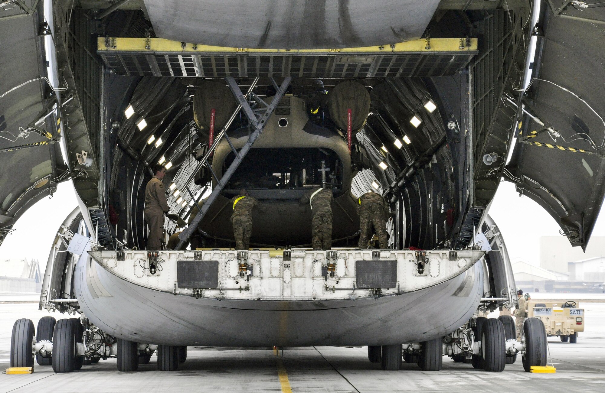 Soldiers from Task Force Destiny pair with Airmen from 9th Airlift Squadron, Dover Air Force Base, Del., to unload a helicopter from a C-5M Super Galaxy at Bagram Airfield, Afghanistan Dec. 26, 2015. The C-5M is the largest military transport aircraft in the world, capable of hauling 270,000 pounds of cargo. (U.S. Air Force photo by Tech. Sgt. Nicholas Rau)