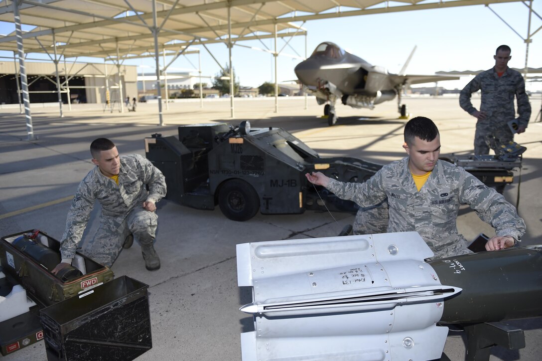 U.S. Airman 1st Class Matthew Wolfel, right, prepares to load an F-35 Lightning ll aircraft during the 4th quarter weapons loading competition on Luke Air Force Base, Ariz., Dec 18, 2015. Wolfel is a weapons load crew member assigned to the 61st Aircraft Maintenance Unit. U.S. Air Force photo by Staff Sgt. Staci Miller