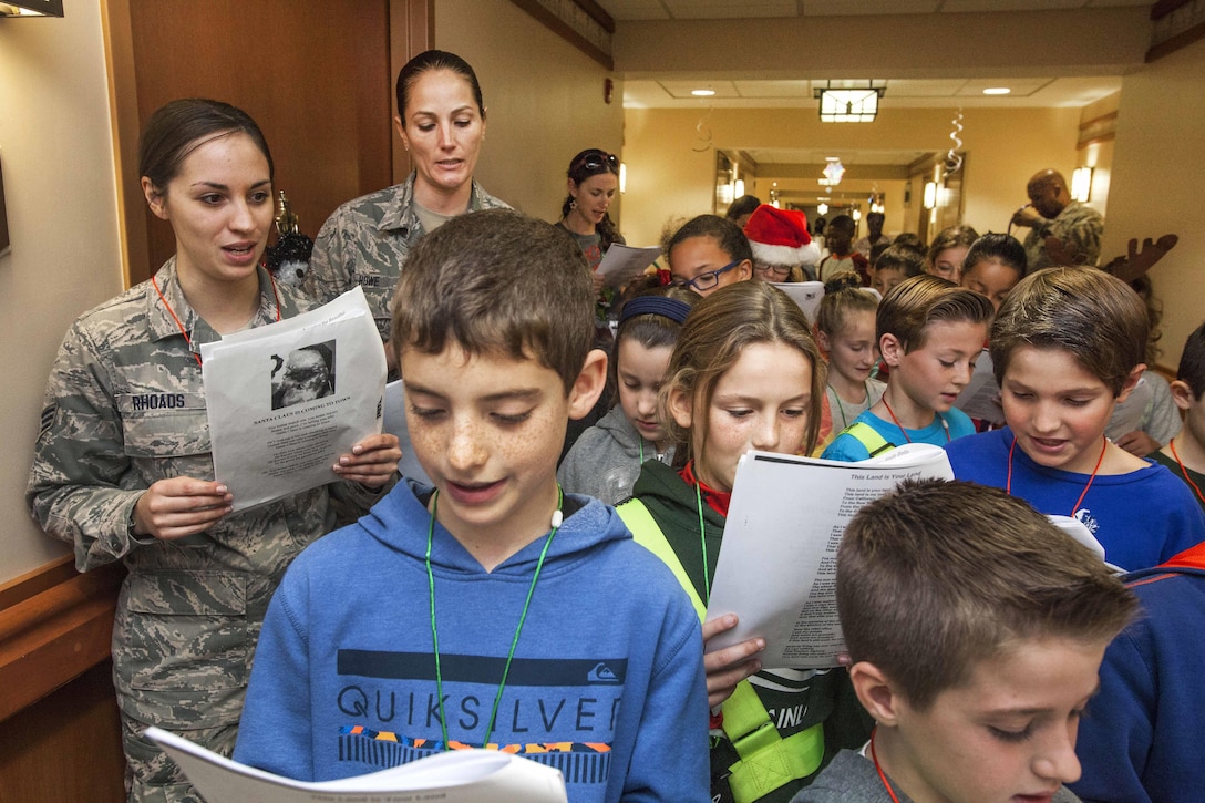 U.S. Air Force Senior Airman Dana Rhoads, left, and Tech. Sgt. Kelly Howe sing along with fourth graders from the Seaview School in Linwood, N.J., during the 15th Annual Holiday "Songfest" at the New Jersey Veterans Memorial Home at Vineland, N.J., Dec. 16, 2015. Rhoads and Howe are assigned to the New Jersey Air National Guard’s 177th Fighter Wing. New Jersey Air National Guard photo by Master Sgt. Mark C. Olsen